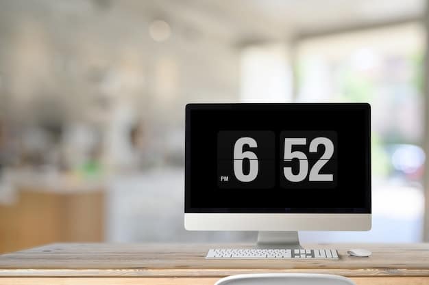 A digital clock on a desk displaying the time, with a blurred background of office workers in a co-working space. The light reflects off the glass of the clock, highlighting its importance as a tool for tracking working hours.