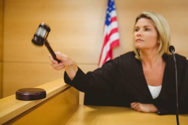 A close-up of a gavel hitting a sound block in a courtroom, with a blurred background of people observing legal proceedings. The wooden textures are prominent, and the lighting suggests a serious and decisive environment.
