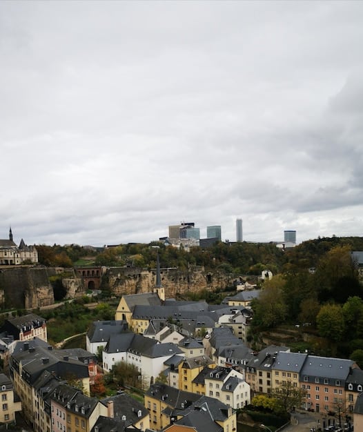An aerial view of a German city known for its diversity, showing landmarks and residential areas with diverse architectural styles. The sky is clear, and the city is seen bustling with activity.