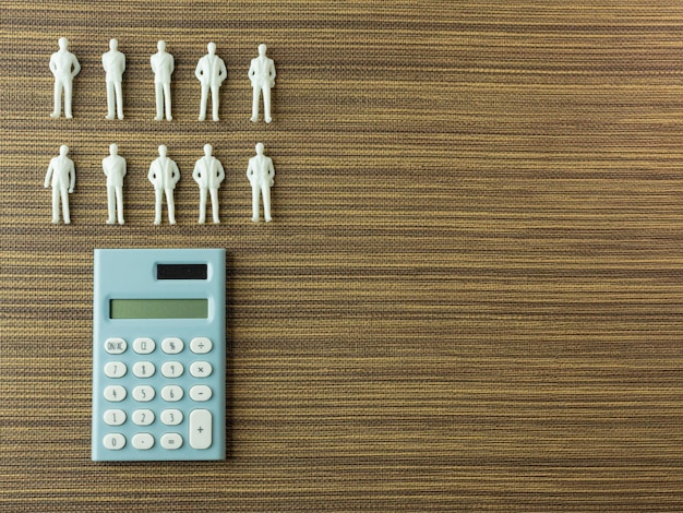 A close-up shot of a calculator displaying increasing numbers, overlaid with silhouettes of various types of workers, portraying the concept of minimum wage increase and its financial implications.